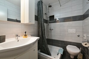 A modern bathroom with a sink, toilet, and shower. - Apartment 1964 (Medulin)