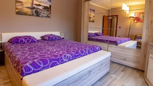 Un dormitorio con una cama, un espejo grande y un cuadro en la pared.