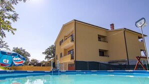 Un edificio de varios pisos con piscina delantera.