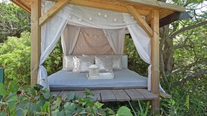 A wooden canopy bed with a mattress, pillows, and a tray in a forested area. - Villa in Frejus With Pool Near Beach (Fréjus)