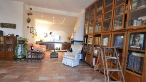 A spacious living area with a fireplace, a large wooden bookshelf, and a dining area. - Peaceful Villa Stay in Rapallo (Rapallo)