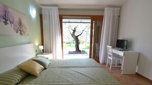 A bedroom with a bed, a desk, and a computer. There is a window with curtains, and a tree is visible outside. - House in Pistoia Countryside (Pistoia)