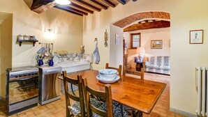 A kitchen with a wooden table, chairs, a stove, and a sink. - Your Home in a Tuscan Tower (Monterchi)