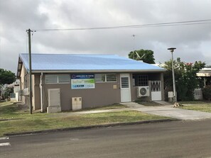 Um edifício com telhado azul, uma placa indicando um centro de ambulância e o número 49 na porta.
