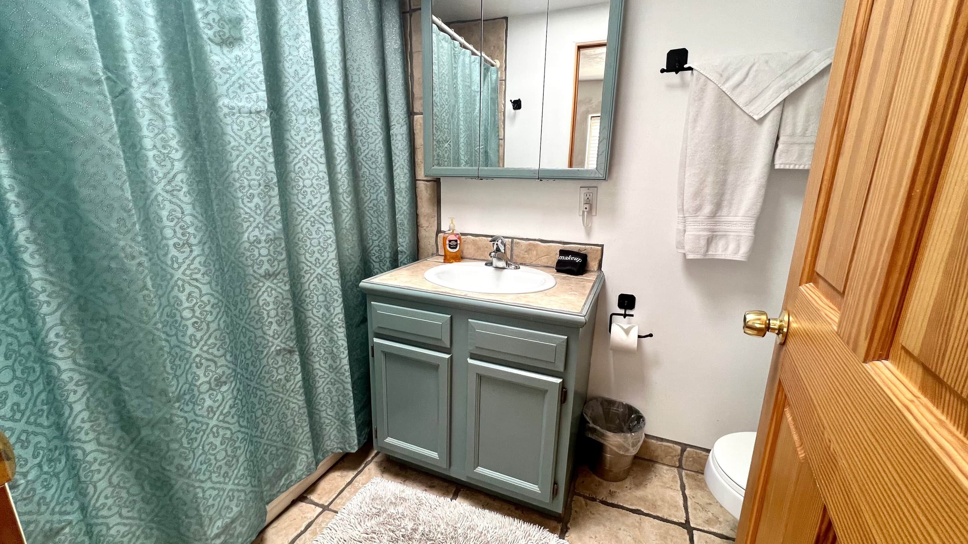 Ein Badezimmer mit Waschbecken, Spiegel und Toilette.