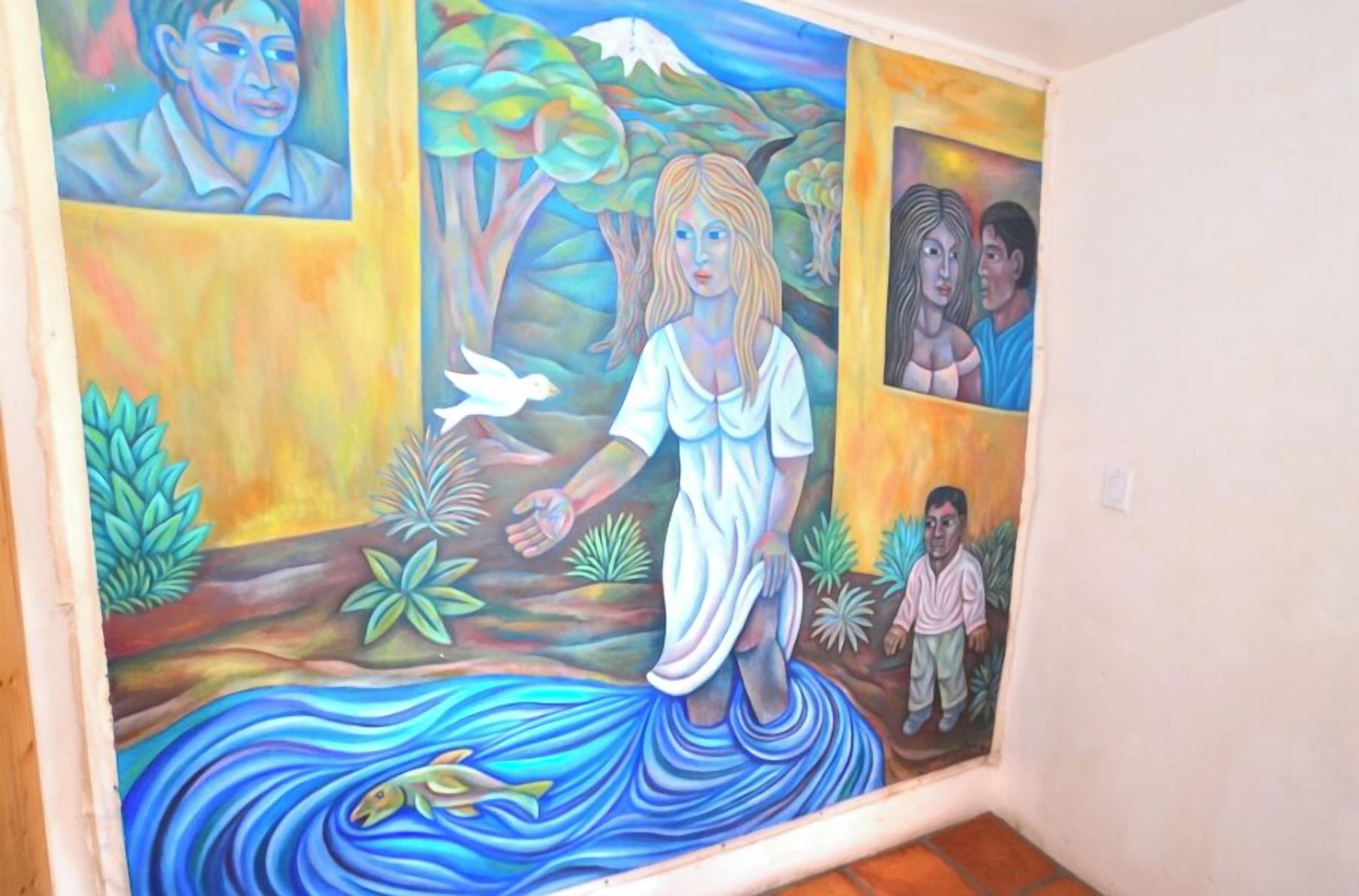 A mural with a woman, children, and a bird in a natural setting.