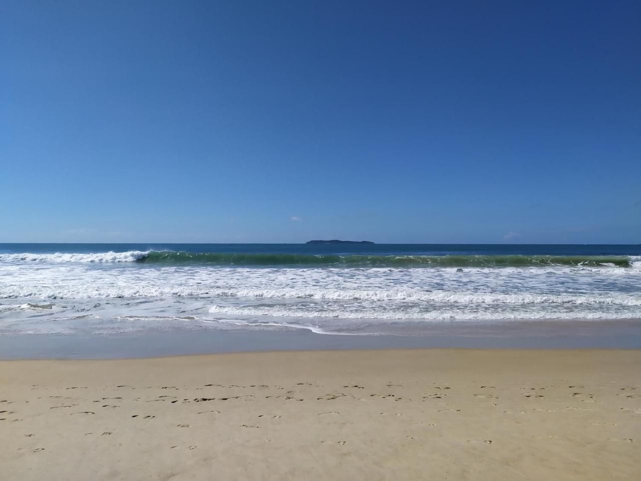 Uma praia com ondas e céu claro.