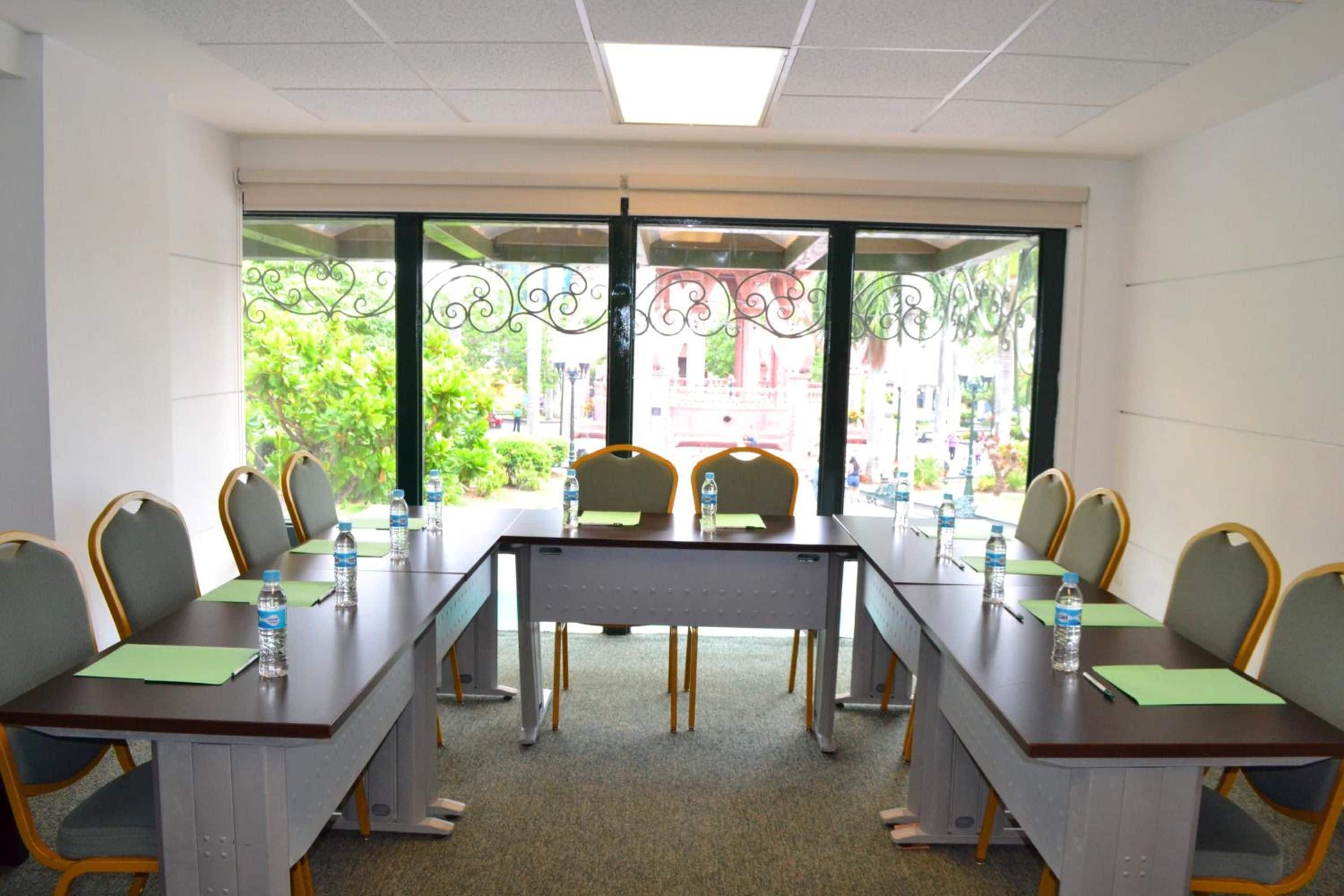 Un salón de conferencias con una larga mesa, sillas y vistas al exterior.