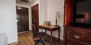 A room with a wooden desk, a chair, a lamp, a television, and a wardrobe. - HS HOTSSON Smart Value Tampico (Tampico)