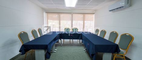 A conference room with a long table, chairs, and a large window.