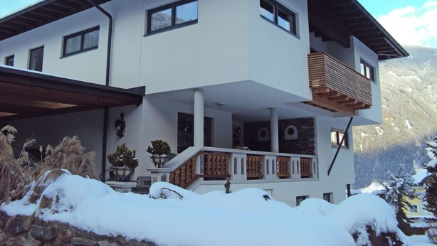 Une maison à deux étages dotée d’un balcon, d’un porche abrité et offrant une vue sur les montagnes.