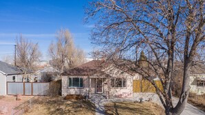 A single-story house with a front yard, a small porch, and a visible garage. - Stir Crazy! Bike Trails, Dogs OK, Food & Nightlife (Colorado Springs)