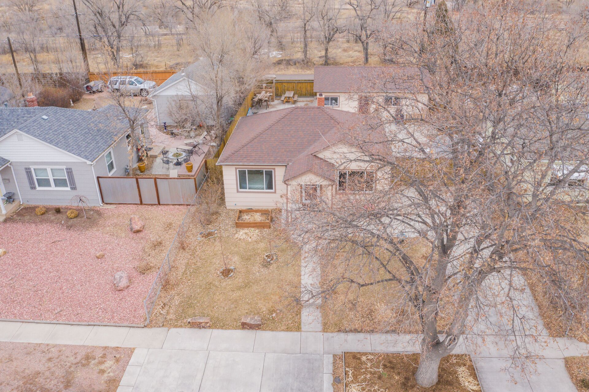 A residential area with houses, a patio, and a tree.