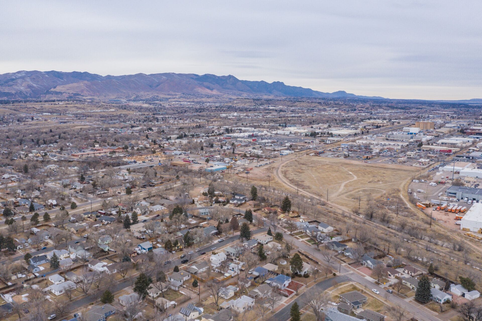 An aerial view of a town with residential areas, roads, and industrial buildings.