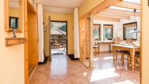 A spacious room with wooden floors, a dining area with a table and chairs, and a large window providing natural light. - Eichenborn Gartenaufenthalt (Bad Pyrmont)