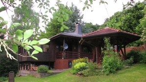 A wooden cabin with a sloped roof and a covered porch. - Eichenborn Gartenaufenthalt (Bad Pyrmont)