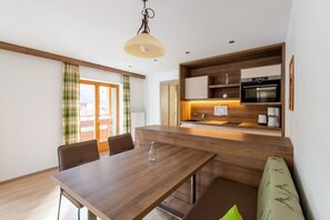A modern kitchen with wooden cabinetry, a built-in oven, and a coffee maker. - Apartment in Wald Near Zillertal Ski Slopes (Wald im Pinzgau)