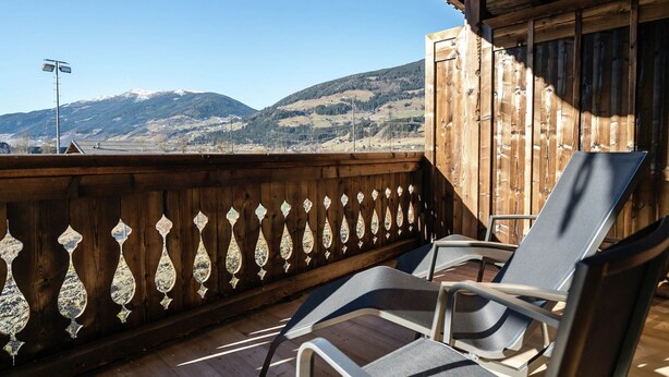 A wooden balcony with a view of snow-capped mountains. - Apartment in Hollersbach With Sauna Near ski Area (Hollersbach im Pinzgau)