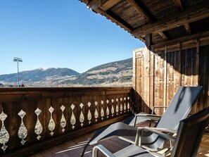 Ein Holzbalkon mit Blick auf schneebedeckte Berge.