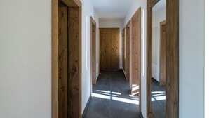 A hallway with wooden doors and a tiled floor. - Apartment in Hollersbach With Sauna Near ski Area (Hollersbach im Pinzgau)