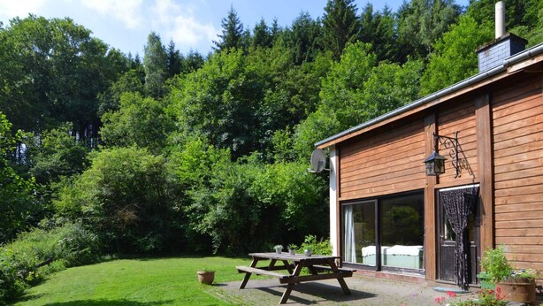 A wooden cabin with a patio, a satellite dish, and a large window. - Family Villa With Garden (Bouillon)