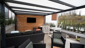 Un patio exterior con un sofá, sillas y una mesa.
