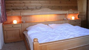 A wooden bed with two bedside tables, each with a lamp.