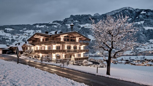 A large, multi-story wooden building with balconies, surrounded by snow-covered landscape and mountains. - Farmhouse in Schwendau With Balcony (Schwendau)