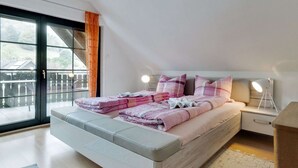 Un dormitorio moderno con una cama grande, una mesita de noche y un ventanal con vistas a un balcón.