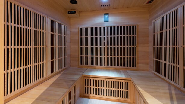 Una sauna con paredes de madera y suelo inclinado.