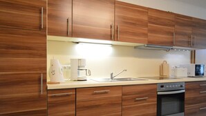 Eine moderne Küche mit Holzausbau, Edelstahlgeräten und einem eingebauten Backofen.