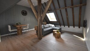 A loft-style room with exposed wooden beams, a gray sofa, a dining table with chairs, and a skylight. - Apartment in North Holland Near Beach (Callantsoog)