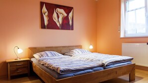 Une chambre à coucher avec un lit en bois, deux tables de chevet, une lampe de chevet et un tableau au mur.
