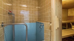 A sauna room with tiled walls, a wooden bench, and a metal handrail. - Apartment in Riezlern Near Ski Slope (Mittelberg)