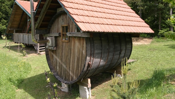 A wooden barrel-shaped building with a sloped roof, a window, and a chimney. - Chalet Near Lake Klopeiner With Sauna (Feistritz ob Bleiburg)