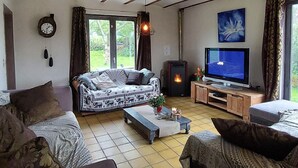 A cozy living room with a sofa, a coffee table, a TV, and a fireplace. - Case Belvene Regio Spa, Theux (Theux)