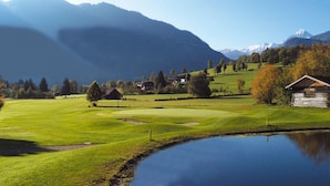 A serene landscape with a pond, green fields, and a mountain in the background. - Spacious Chalet near Ski Area in Saalbach-Hinterglemm (Viehhofen)