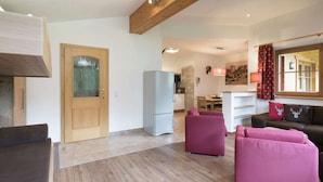 A modern living room with a wooden ceiling, a dining area, and a kitchen. - Spacious Chalet near Ski Area in Saalbach-Hinterglemm (Viehhofen)
