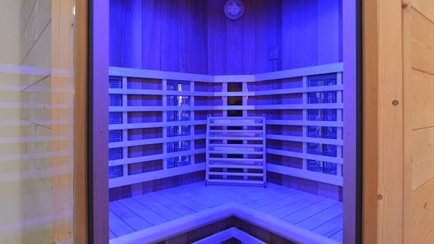 A sauna with wooden walls and benches, equipped with a clock on the ceiling. - Apartment in Burg Reuland With Forest (Burg-Reuland)