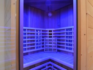 A sauna with wooden walls and benches, equipped with a clock on the ceiling. - Apartment in Burg Reuland With Forest (Burg-Reuland)