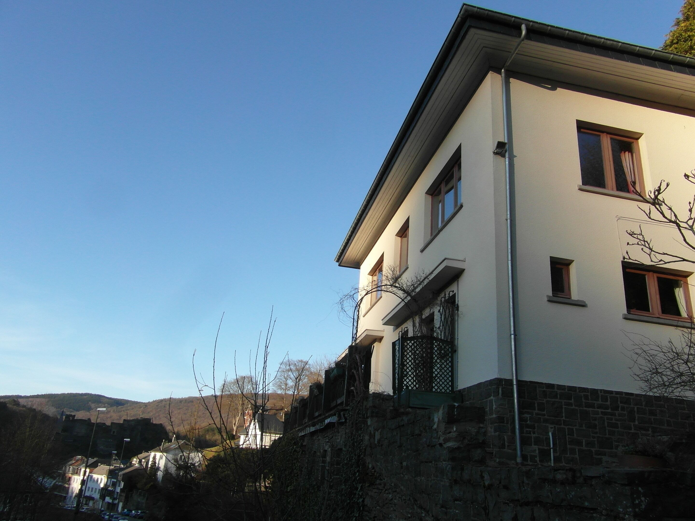 A two-story building with a stone base and a white upper section.