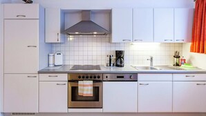 A modern kitchen with white cabinets, a stainless steel oven, a coffee maker, and a sink. - Cozy Holiday Home in Vandans near Montafon Ski Area (Vandans)