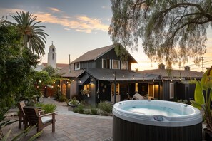 Une maison avec un jacuzzi, un espace salon extérieur et une vue sur une église.
