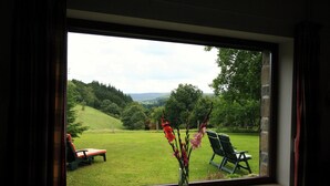 A window with a view of a grassy area and chairs outside. - Cozy Holiday Home in Lesterny near Lake (Nassogne)