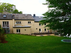 A two-story house with a small garden, a trampoline, and a covered outdoor seating area. - Beautiful Group House With Large Garden (Gouvy)