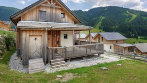 Eine Holzhütte mit Balkon in einer Berglandschaft.