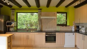 A modern kitchen with wooden cabinets, a built-in oven, and a dishwasher. - Elegant Beverce Escape (Malmedy)