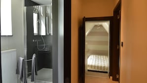 Ein Schlafzimmer mit Bett, Dusche und Blick ins Freie.