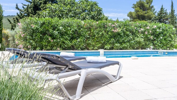 A poolside area with lounge chairs and a swimming pool. - Villa in Pouzols With Private Pool & Vineyards (Pouzols-Minervois)