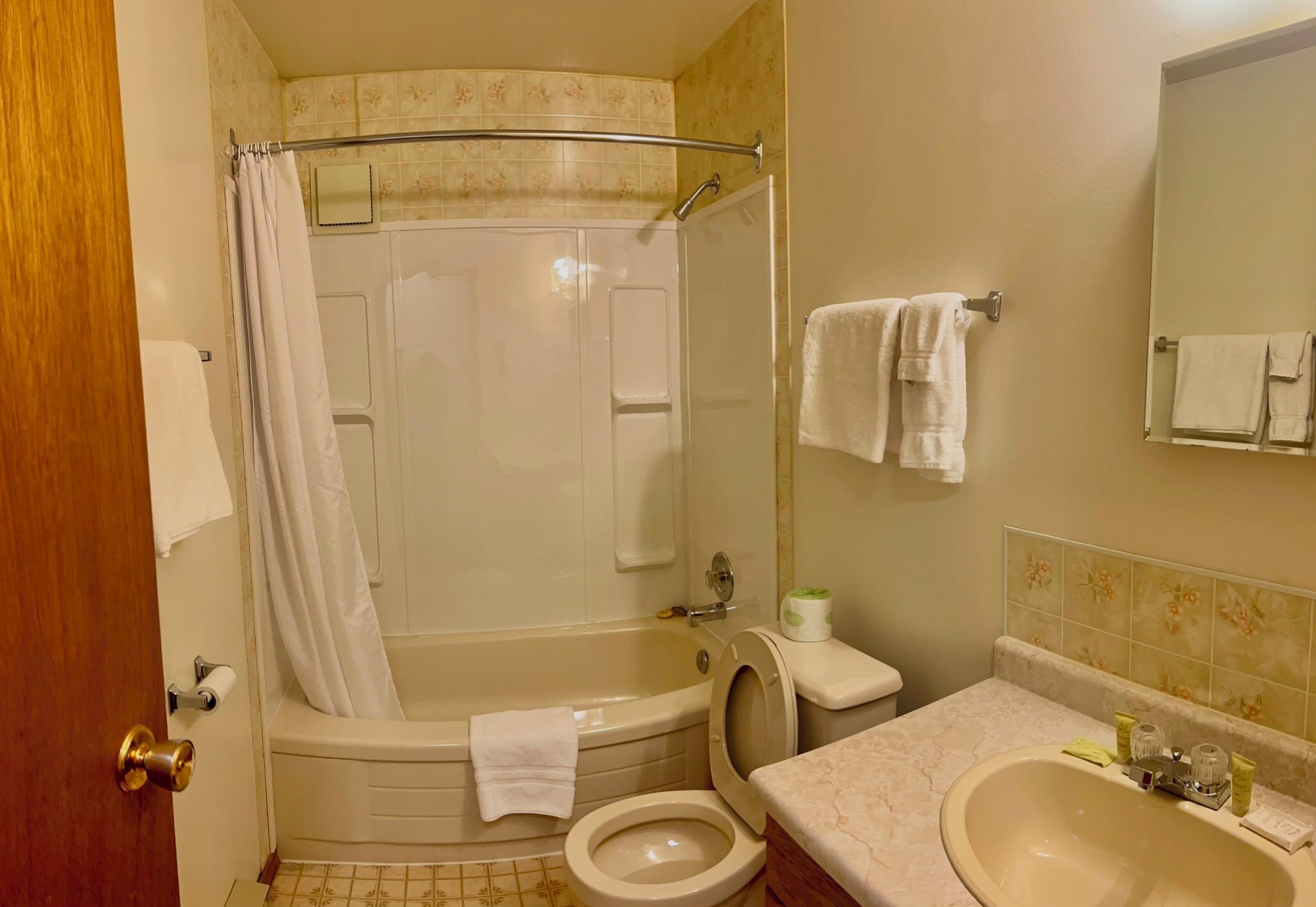 Une salle de bain équipée d’une baignoire, de toilettes, d’un lavabo et d’un rideau de douche.